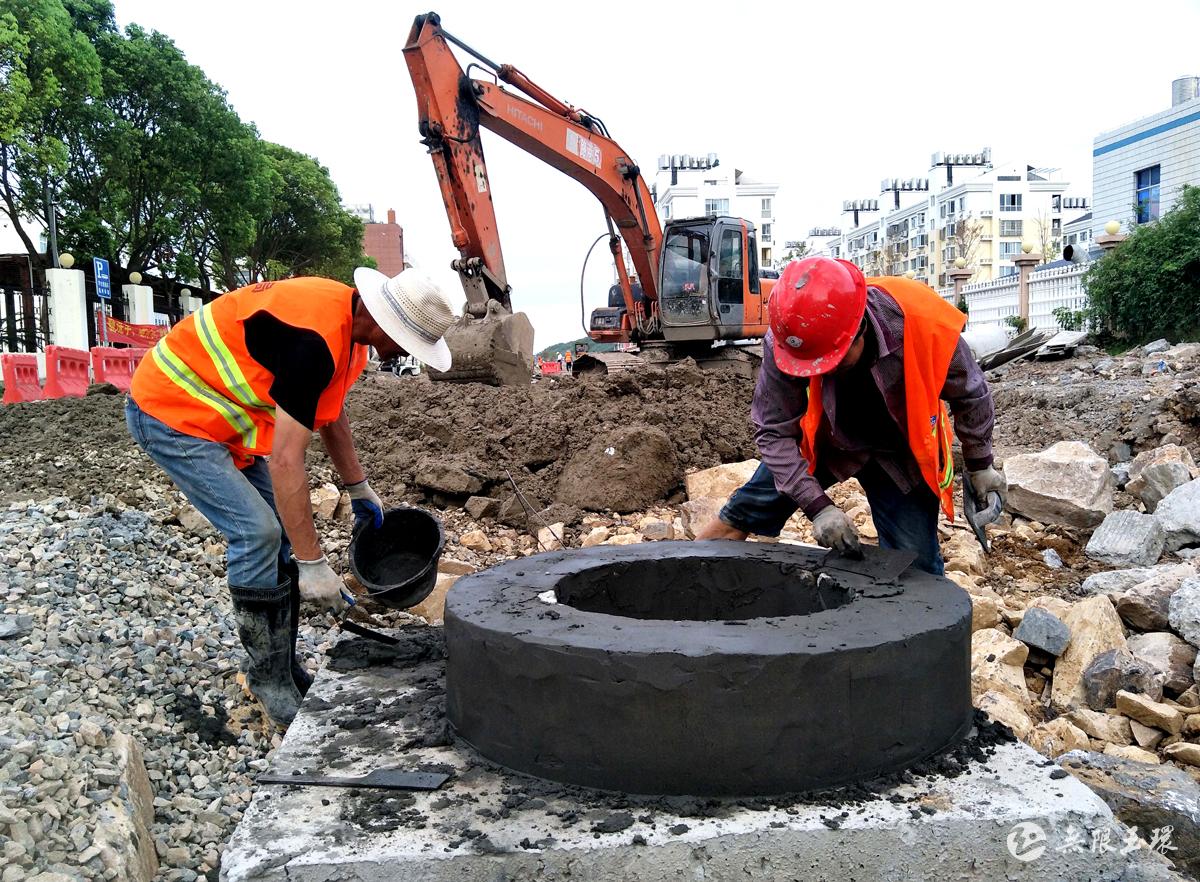 9月3日,在玉环市干江镇育才路,工人们正在垒砌排雨水暗井,挖掘机